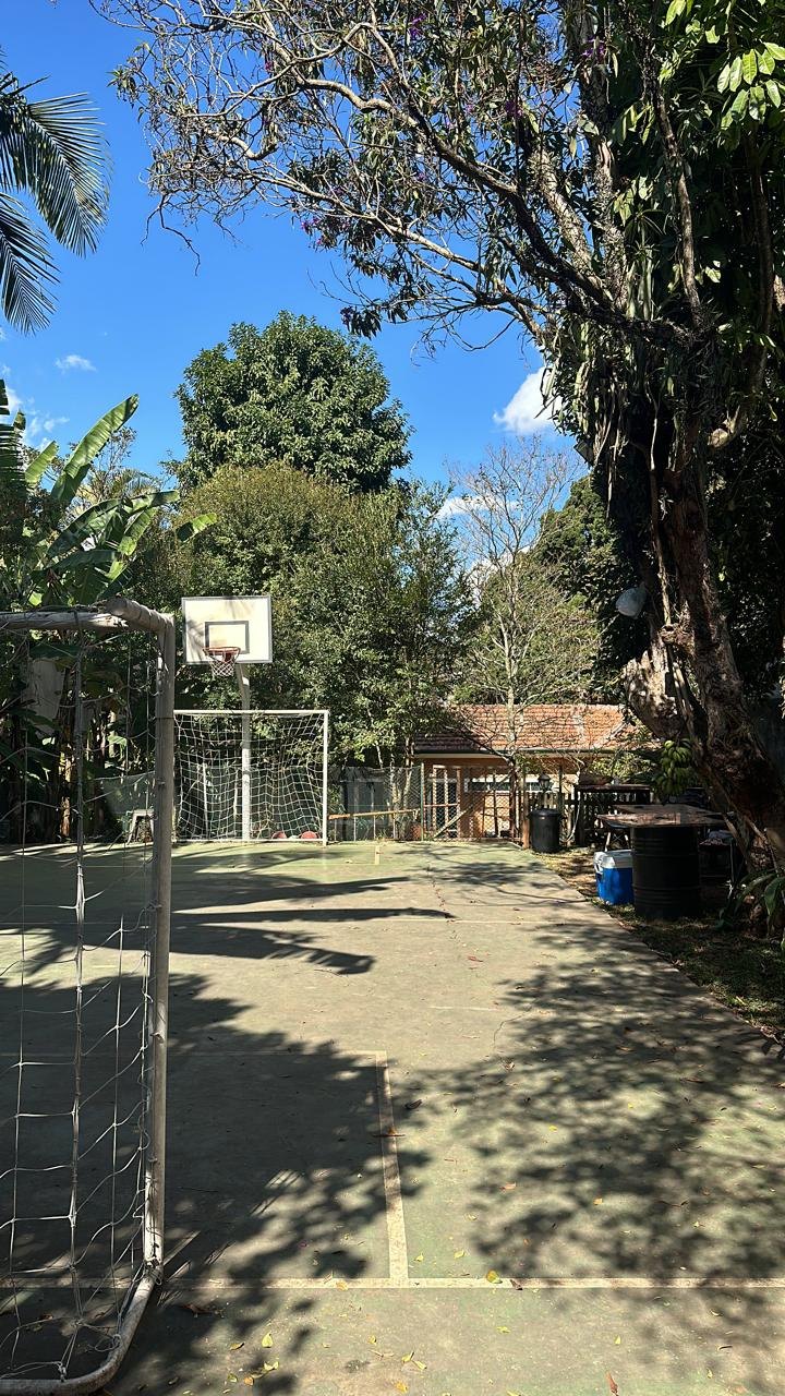 Quadra da Big House com traves, tabela de basquete e árvores em volta